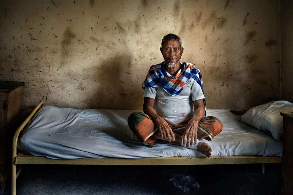 Ein Patient sitzt auf seinem Bett im Lepra-Spital in Bangladesch