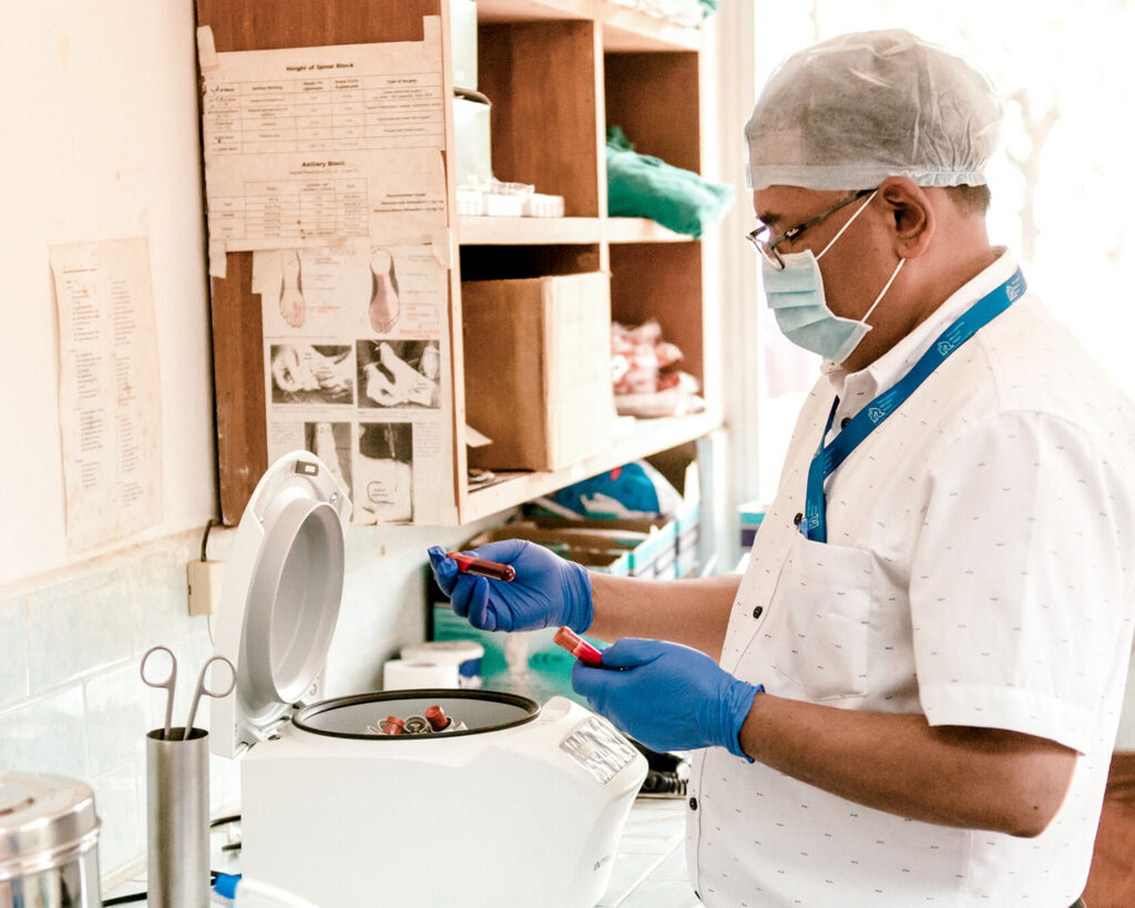 Le Dr. Napit place le sang dans une centrifugeuse pour séparer les cellules sanguines.