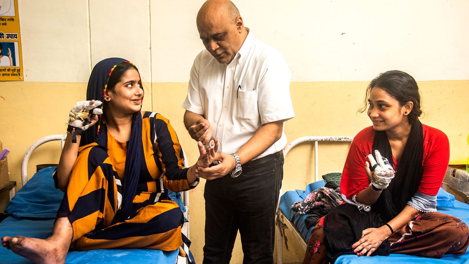 Ein Arzt untersucht zwei Leprapatientinnen in Indien