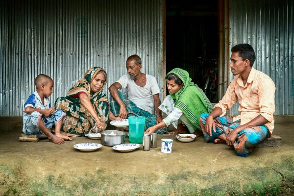 Eine von Lepra betroffene Frau isst mit ihren Enkeln