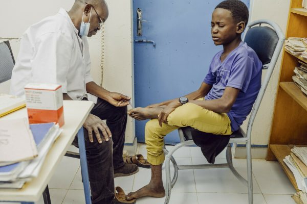 Ein Arzt untersucht einen Jungen auf Lepra